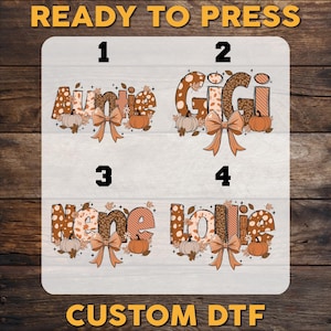 May include: A set of four custom DTF transfers labeled 1 through 4, featuring the words Auntie, Gigi, Nene, and Lollie in brown and orange patterns. Each design includes autumn-themed elements like pumpkins, fall leaves, and a decorative bow.