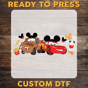 Pu&ograve; includere: Un design di auto di cartone animato rosso e marrone con orecchie di Topolino su ogni auto. Le auto sono circondate da cibi di cartone animato come waffle a forma di Topolino, pizza, cupcake e patatine fritte. Il design &egrave; su uno sfondo bianco con il testo "READY TO PRESS CUSTOM DTF" in alto e in basso.