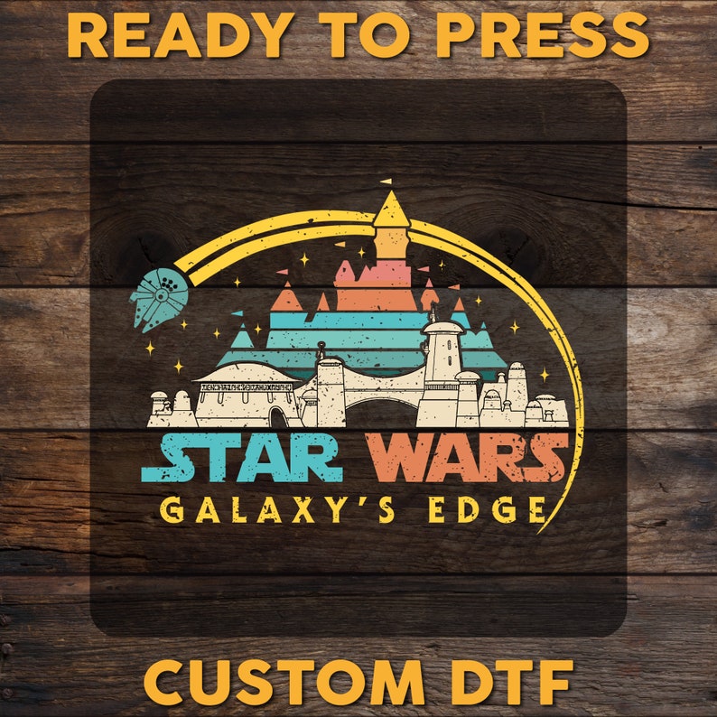 K&ouml;nnte beinhalten: Ein Design im Retro-Stil mit einem stilisierten Bild einer Burg mit dem Text "STAR WARS GALAXY'S EDGE" darunter. Das Design befindet sich auf einem Holzmaserungshintergrund mit dem Text "READY TO PRESS CUSTOM DTF" dar&uuml;ber und darunter.