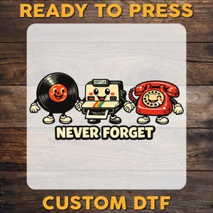 May include: A graphic design featuring a black vinyl record, a beige instant camera, and a red rotary telephone as cartoon characters holding hands. The text "READY TO PRESS" appears at the top, "NEVER FORGET" in the center, and "CUSTOM DTF" at the bottom.
