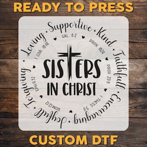 May include: A white iron-on transfer design with black text that reads "Sisters in Christ" surrounded by a circle of words and bible verses. The words include "Loving", "Supportive", "Kind", "Faithful", "Encouraging", and "Joyful".