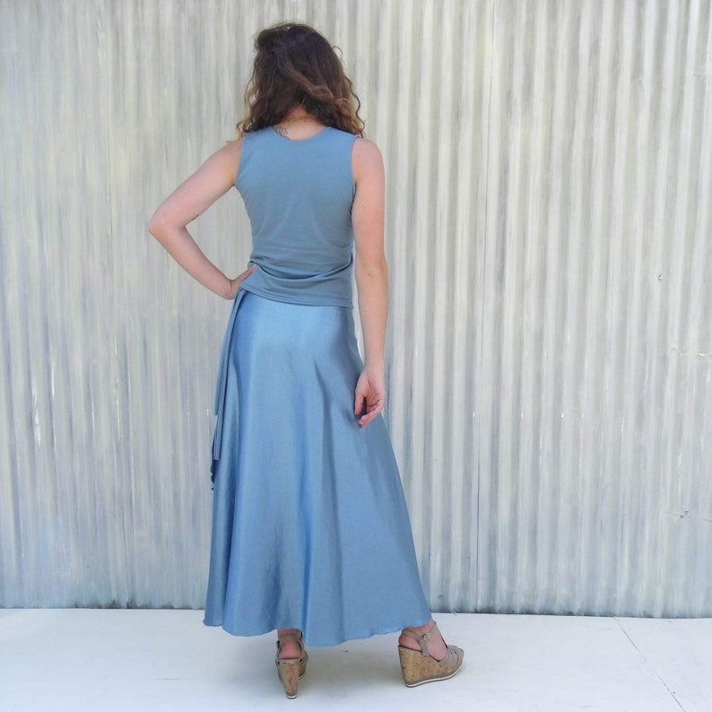 Puede incluir: Una blusa azul claro sin mangas con una falda maxi azul claro a juego. La falda est&aacute; fruncida en la cintura y cae hasta los tobillos.