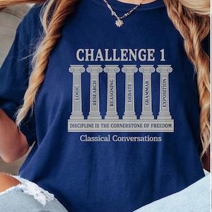 May include: Navy blue t-shirt with the text "CHALLENGE 1" above six columns labeled "LOGIC", "RESEARCH", "REASONING", "DEBATE", "GRAMMAR", and "EXPOSITION". Below the columns is the text "DISCIPLINE IS THE CORNERSTONE OF FREEDOM" and "Classical Conversations".