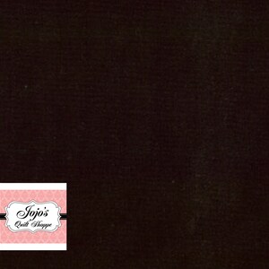 Puede incluir: Tela negra con una etiqueta rosa y blanca que dice "Jojo's Quilt Shoppe" en una fuente blanca de escritura.