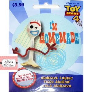 Può includere: Una toppa adesiva rotonda azzurra con il personaggio Forky di Toy Story 4. La toppa presenta la scritta "I'M HOMEMADE" in rosso e blu. La toppa è confezionata su uno sfondo blu e bianco.