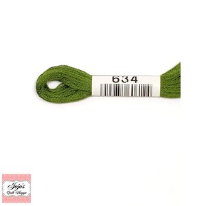 May include: A skein of green embroidery floss with a white label that says "634" and has a barcode.