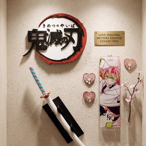 May include: A display featuring a Japanese anime theme. It includes a decorative sign with Japanese characters, a sword, a banner, and heart-shaped pins. The color palette includes white, black, pink, and teal.