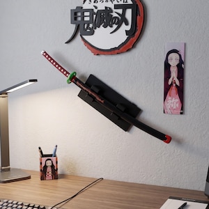 May include: A wall display with a katana sword, a circular emblem with Japanese text, and a character portrait. The sword has a red and black handle and a green guard. A desk with a keyboard, mouse, and pen holder is in the foreground.