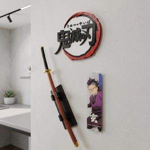 May include: Anime-themed wall decorations featuring a katana replica, a circular emblem with Japanese text, and a clear acrylic character figure. The katana has a black handle and brown blade. The emblem has a red border.