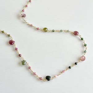Pode incluir: Um colar de corrente de ouro com pedras preciosas rosa, verde e preta. O colar &eacute; feito de pequenas contas delicadas e &eacute; perfeito para o uso di&aacute;rio.