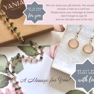 Puede incluir: Un collar de cadena de oro con piedras preciosas rosas, verdes y negras. El collar est&aacute; en una caja con un mensaje que dice "D&eacute;janos enviar tu regalo para ti". La caja est&aacute; sobre una superficie blanca con un patr&oacute;n floral. El texto "&iexcl;Un mensaje para ti!" est&aacute; escrito en la superficie. La imagen tambi&eacute;n muestra un par de pendientes de piedras preciosas rosas con engastes de oro. El texto "Envolvemos cada pedido con amor" est&aacute; sobre un fondo gris.