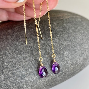 May include: A pair of gold chain earrings with purple amethyst gemstone drops.