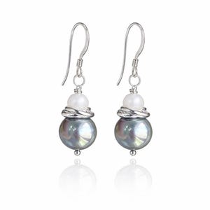 May include: A pair of dangle earrings featuring a large, iridescent gray pearl, a smaller white pearl, and silver-toned metal accents. The earrings have a hook closure and a reflective surface.