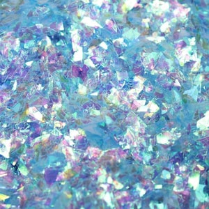 May include: A close-up of iridescent blue glitter, ideal for crafting and adding sparkle to projects.
