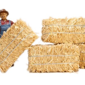 May include: Four bales of straw tied with twine, stacked on top of each other. The straw is a light brown color and has a rough texture.