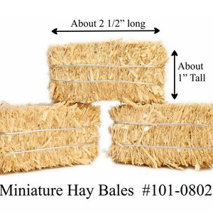 May include: Three miniature hay bales, each about 2 1/2 inches long and 1 inch tall. Miniature Hay Bales #101-0802