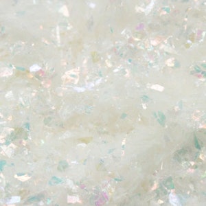May include: A close-up of iridescent white glitter, perfect for crafting and adding sparkle to projects.