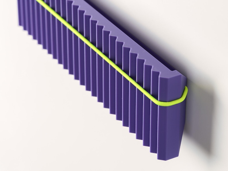 May include: A geometric, abstract design featuring a purple, ridged structure with a neon yellow band wrapped around it. The object is set against a white background, creating a modern aesthetic.