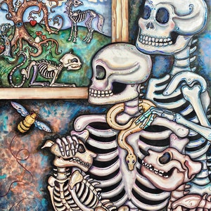 May include: A colorful painting featuring skeletal figures and animals. The artwork includes a family of skeletons, a dog skeleton, a snake, and a bee. A framed scene depicts a tree, a horse skeleton, and a cat skeleton. The painting has a whimsical and artistic style.