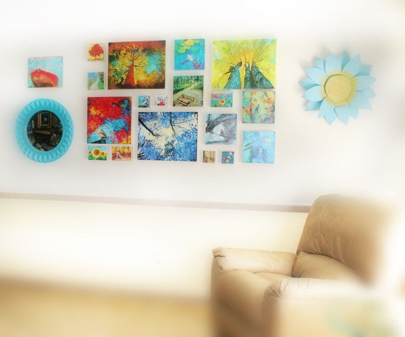 May include: A gallery wall with a variety of colorful framed artwork, including landscapes, nature scenes, and abstract designs. A blue and white paper flower decorates the wall.