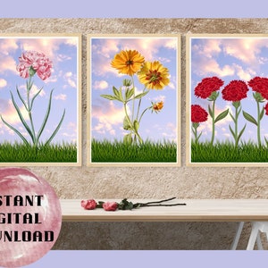 May include: Three framed prints of floral arrangements against a blue sky background. The first print features a pink carnation, the second print features a yellow flower, and the third print features red carnations.