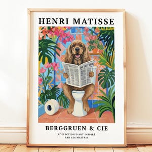 Puede incluir: Una impresión artística enmarcada que muestra un perro en un inodoro leyendo el periódico "The Daily Bark". La obra de arte está en un estilo colorido inspirado en Matisse, con el texto "HENRI MATISSE" y "BERGGRUEN & CIE".