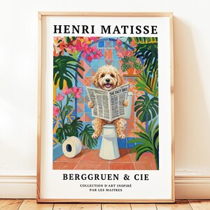 May include: A framed art print depicting a dog reading a newspaper titled "The Daily Bark" on a toilet. The artwork is set in a colourful bathroom with plants. The print includes the text "HENRI MATISSE" and "BERGGRUEN & CIE".