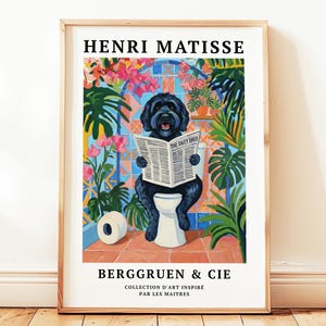 Könnte beinhalten: Gerahmter Kunstdruck mit einem schwarzen Hund auf einer Toilette, der eine Zeitung mit dem Titel "The Daily Bark" liest. Das Kunstwerk ist in einem farbenfrohen, von Matisse inspirierten Stil gehalten, mit Text oben und unten.
