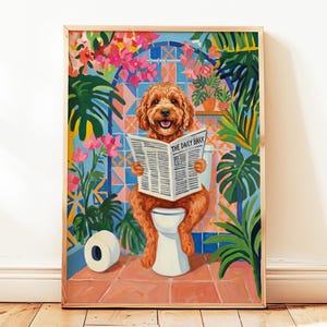 Puede incluir: Una impresión artística enmarcada representa a un perro marrón sentado en un inodoro, leyendo el periódico "The Daily Bark". El fondo presenta un colorido diseño floral y de azulejos con exuberante vegetación y un rollo de papel higiénico.