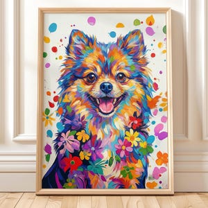 May include: A framed art print of a Pomeranian dog, depicted with a vibrant, colourful palette. The dog's fur is a mix of blues, oranges, and yellows, with floral details. The background is white with colourful paint splatters.