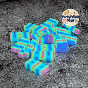 K&ouml;nnte beinhalten: Eine Ansammlung farbenfroher, rechteckiger Zappelspielzeuge in Blau-, Gr&uuml;n-, Rosa- und Lilat&ouml;nen. Die Spielzeuge sind in einem Haufen angeordnet, mit einem kreisf&ouml;rmigen Logo oben rechts mit der Aufschrift "PartyPrank Deals".