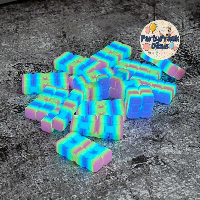 K&ouml;nnte beinhalten: Eine Ansammlung farbenfroher, rechteckiger Zappelspielzeuge in Blau-, Gr&uuml;n-, Rosa- und Lilat&ouml;nen. Die Spielzeuge sind in einem Haufen angeordnet, mit einem kreisf&ouml;rmigen Logo oben rechts mit der Aufschrift "PartyPrank Deals".