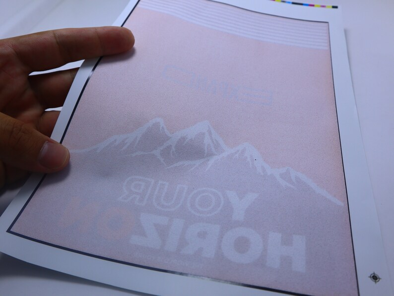 May include: A white print on a pink background with a mountain range and the text "HORIZ YOUR" in white.