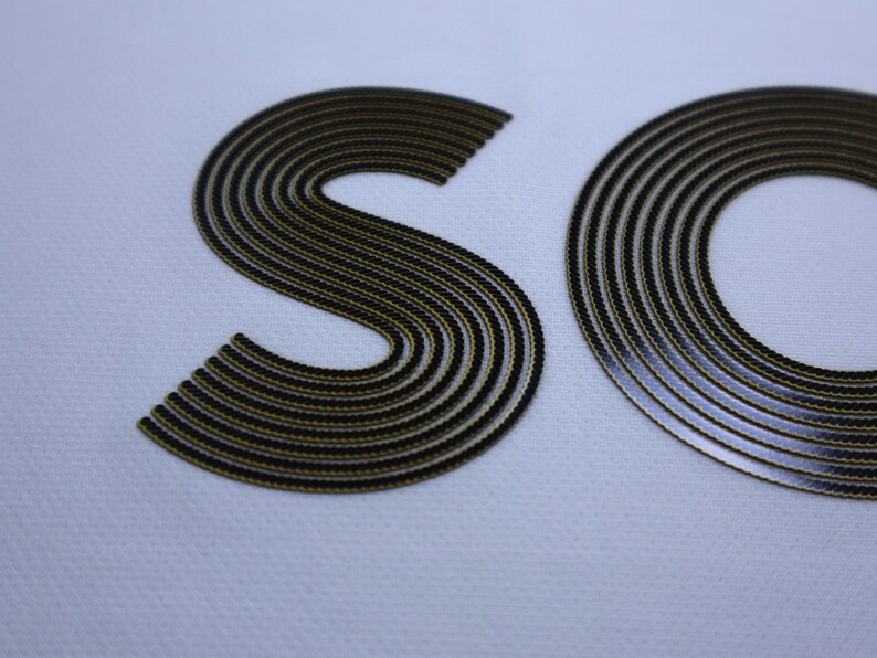 Pode incluir: Close-up de um logotipo "SO" preto e dourado com um design texturizado e em camadas.