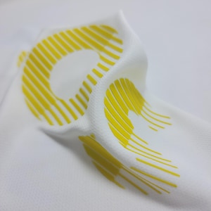 May include: White fabric with a yellow, striped, graphic design.