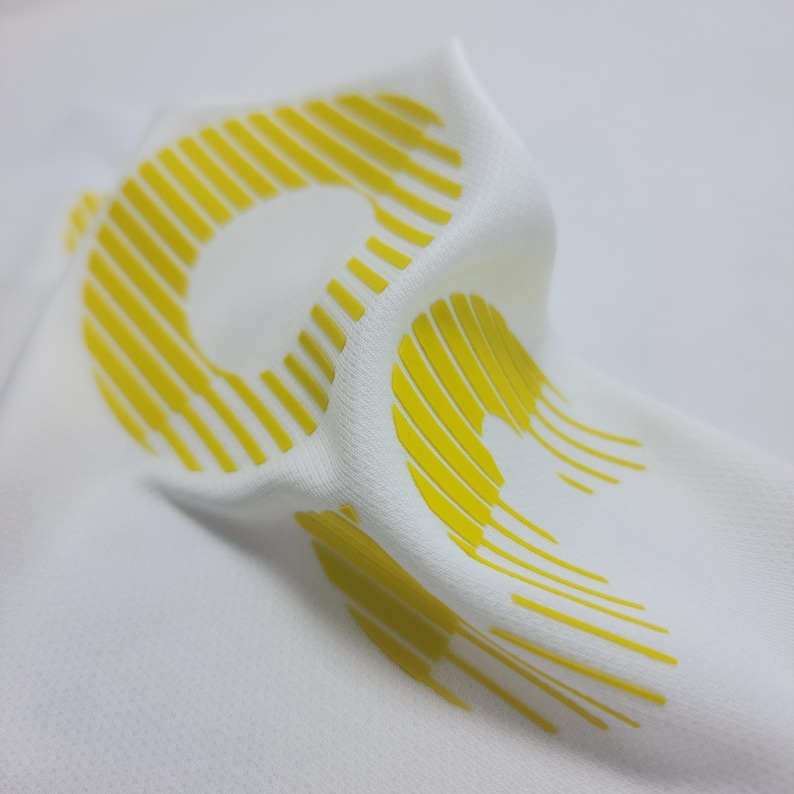 May include: White fabric with a yellow, striped, graphic design.