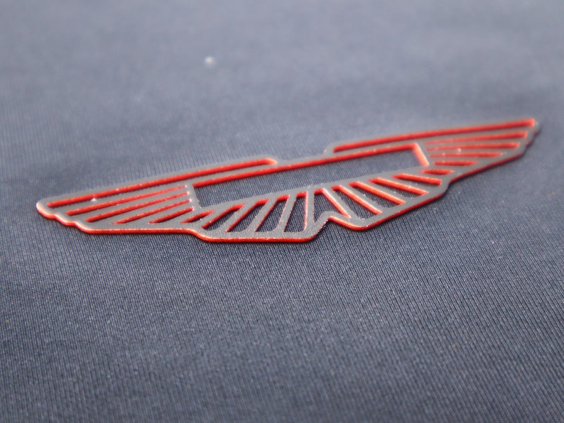 May include: A red winged logo on a dark blue fabric background.