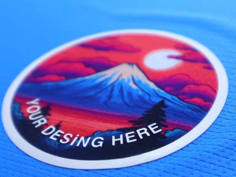 K&ouml;nnte beinhalten: Ein wei&szlig;er runder Patch mit einem bunten Bild einer Bergkette und einem roten Himmel. Der Text "YOUR DESING HERE" ist in Wei&szlig; auf dem Patch gedruckt.