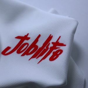 Puede incluir: Tela blanca con la palabra "Jobbists" impresa en rojo.