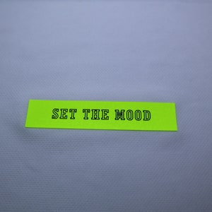 May include: A bright green sticky note with the text "SET THE MOOD" written in black.