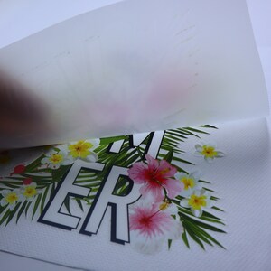 May include: A white t-shirt with a tropical print featuring pink and yellow flowers, green leaves, and the word "SUMMER" in black letters.