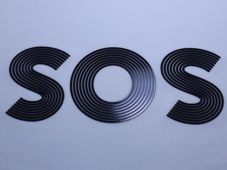 May include: A close-up of the word "SOS" written in black, with each letter made up of concentric circles.