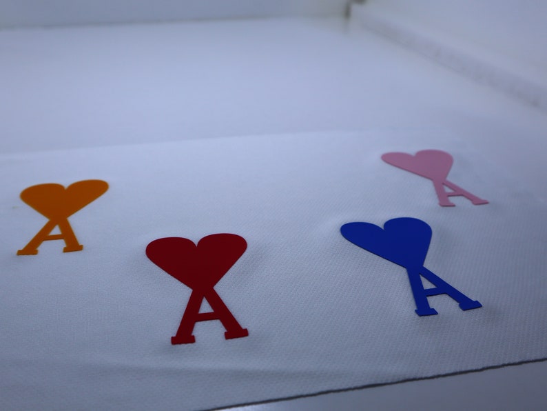 May include: Four felt hearts with the letter 'A' inside, each heart is a different color: orange, red, blue, and pink.