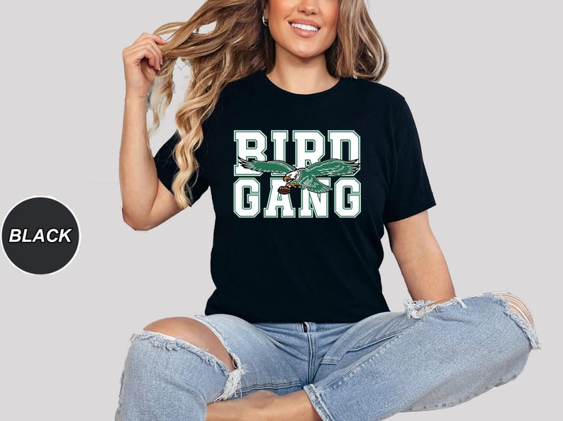 May include: A black t-shirt with a green and white graphic of a bird with the text "BIRD GANG" on it.