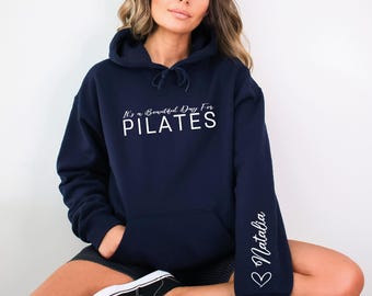 May include: A navy blue hoodie with the text "It's a Beautiful Day For PILATES" in white. The right sleeve has the name "Natalia" written in white with a heart.