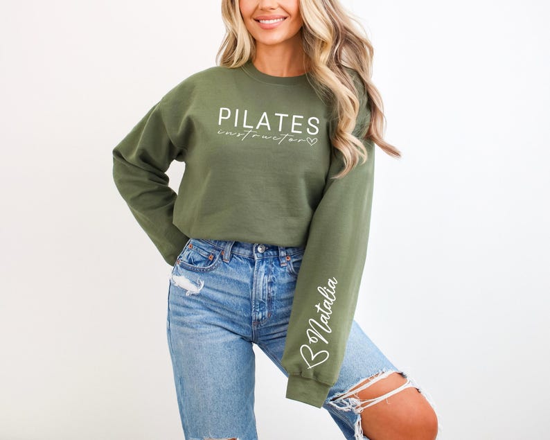 May include: A green sweatshirt with the text "PILATES instructor" and a heart symbol. The left sleeve has the name "Natalia" written on it.