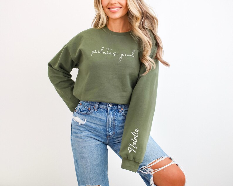 May include: A green sweatshirt with the text "pilates girl" on the front and the name "Natalia" on the sleeve.