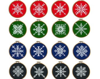 Puede incluir: Doce diseños de copos de nieve bordados en aros de madera. Los copos de nieve son blancos, sobre fondos rojos, verdes, azules y negros. Los aros de bordado están dispuestos en forma de cuadrícula.