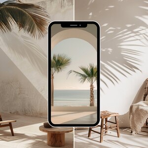 May include: A smartphone displaying a photo of a beach scene through an archway. The phone is sitting on a wooden table in a room with a wicker chair and a white wall. The wall has shadows of palm trees cast on it.