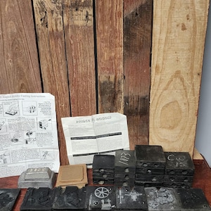 May include: A set of vintage metal casting molds for making toy soldiers, horses, and wheels. The molds are black and have a worn, aged look. The set includes instructions for using the molds, which are printed on a sheet of paper with the text "August Hobby - Casting Instructions".